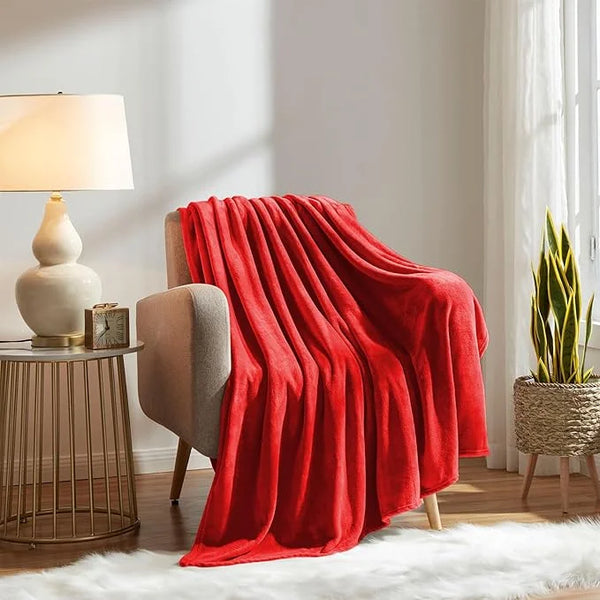 Red blanket draped over a chair in a cozy living room setting.
