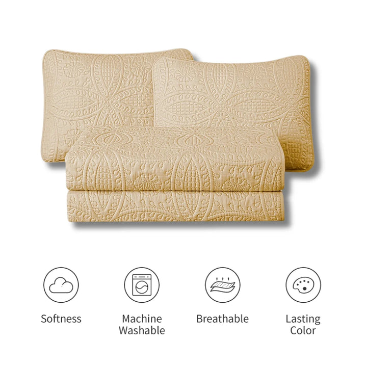 Beige quilt with embossed pattern on a white background, featuring icons for softness, machine washability, breathability, and lasting color.