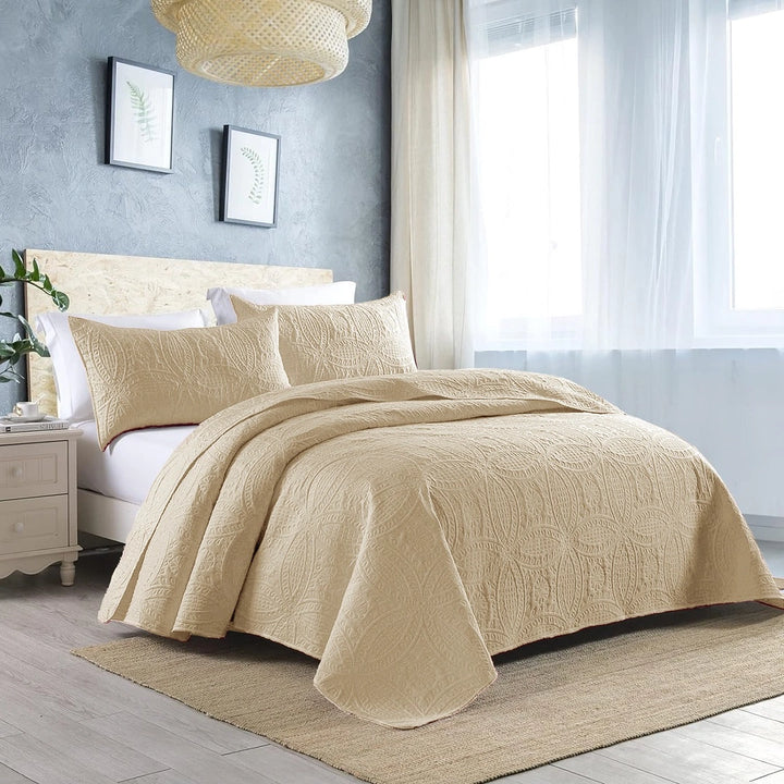 beige quilted bedspread set on bed with amazing background 