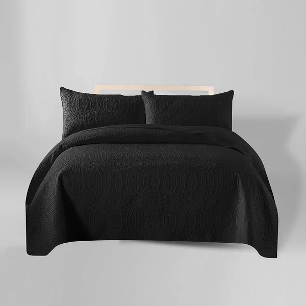 Black bedding set on a bed with a plain background