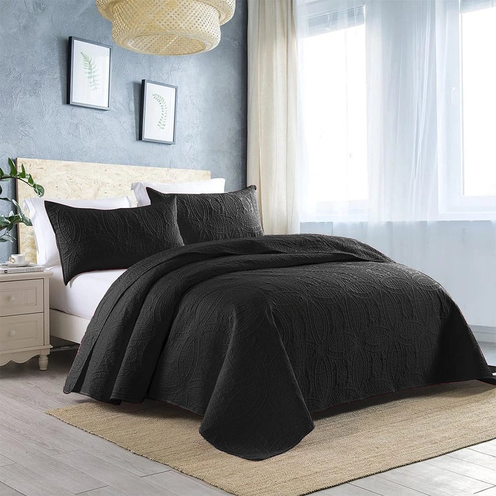 black quilted bedspread set on bed with amazing background 