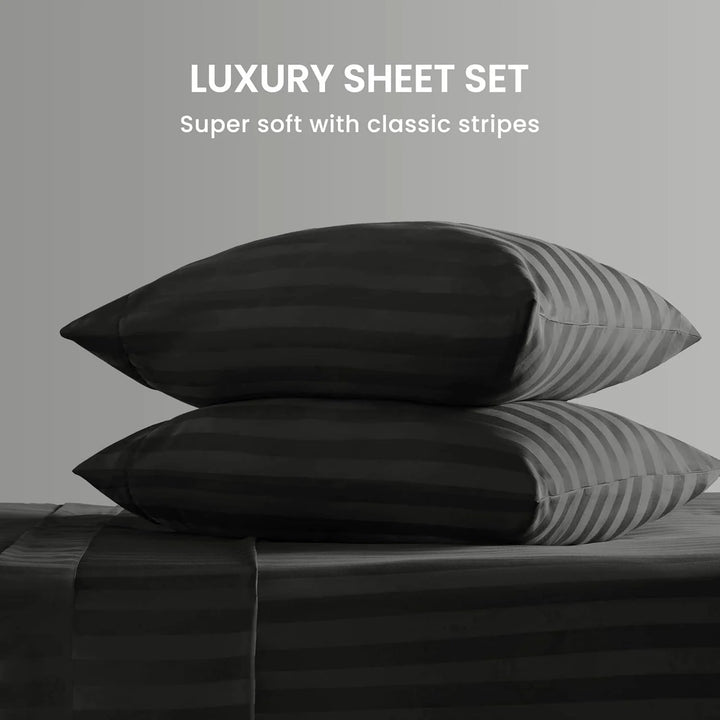 Stack of black and gray striped pillows on a bed with text 'Luxury Sheet Set' and 'Super soft with classic stripes'.