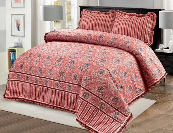 Red floral patterned comforter set on a bed in a bedroom setting.