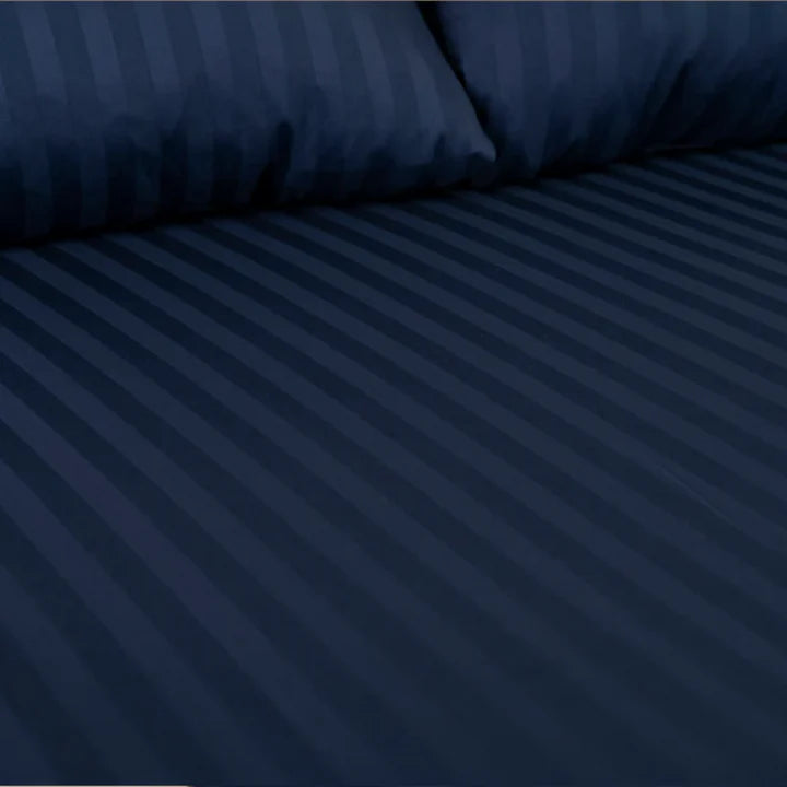Navy blue striped bedding set on a bed