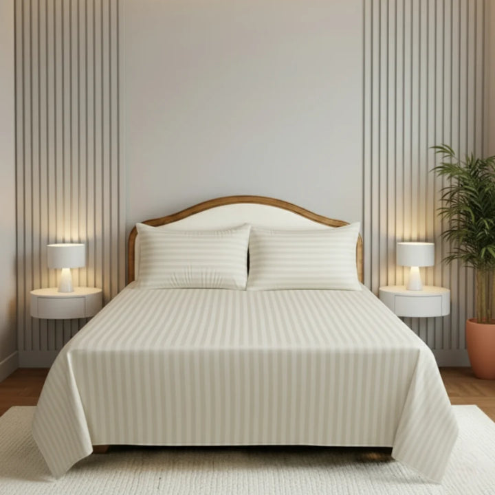 Neatly made bed with striped bedding in a bedroom setting.