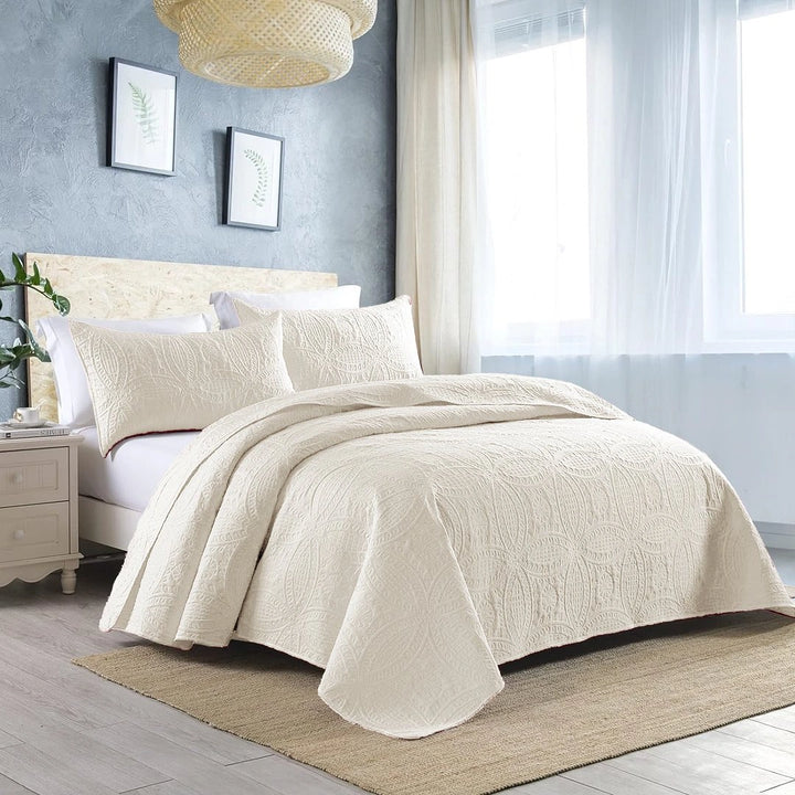 off white quilted bedspread set on bed with amazing background 