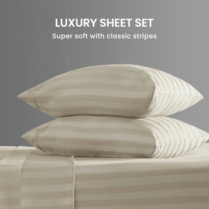 Two pillows on a bed with striped bedding against a gray background, labeled 'Luxury Sheet Set'.