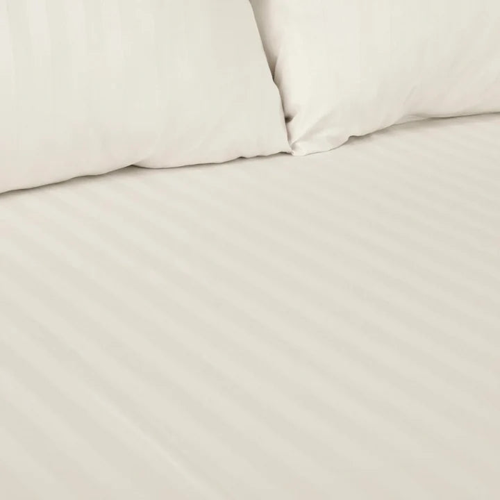 Close-up of beige bedding with a pillow and duvet cover.