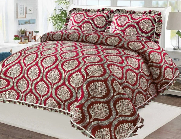 Red and white patterned comforter set on a bed in a bedroom.