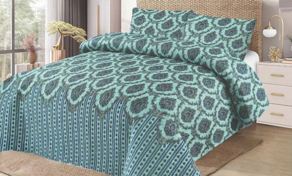Teal patterned bedding set on a bed in a bedroom.