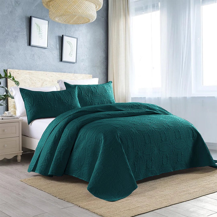 teal quilted bedspread set on bed with amazing background 