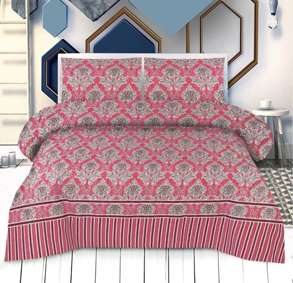 Pink and gray patterned bedspread set on a bed with decorative wall art in the background.