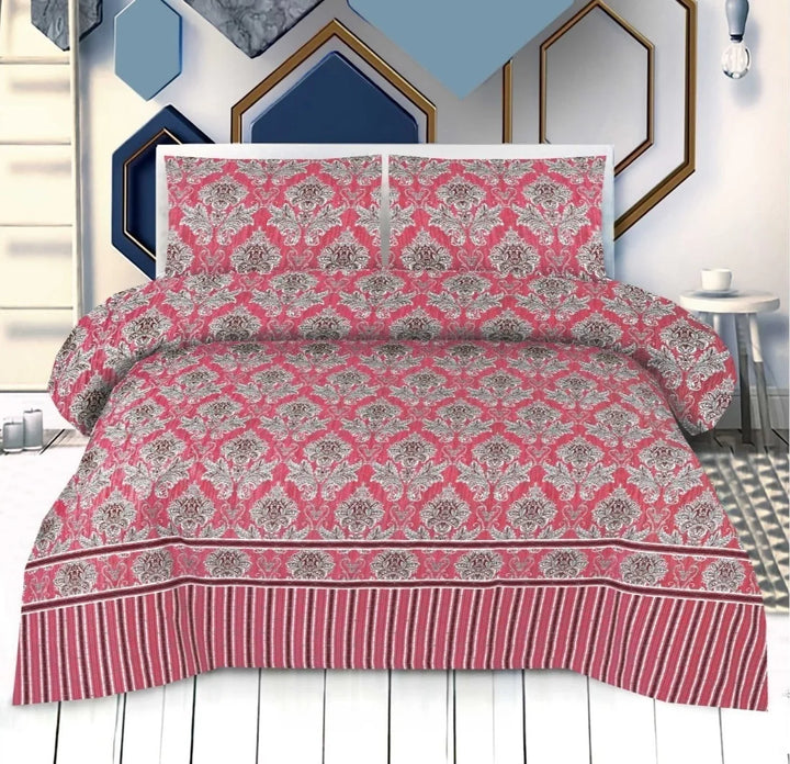 Pink and gray patterned bedspread set on a bed with decorative wall art in the background.