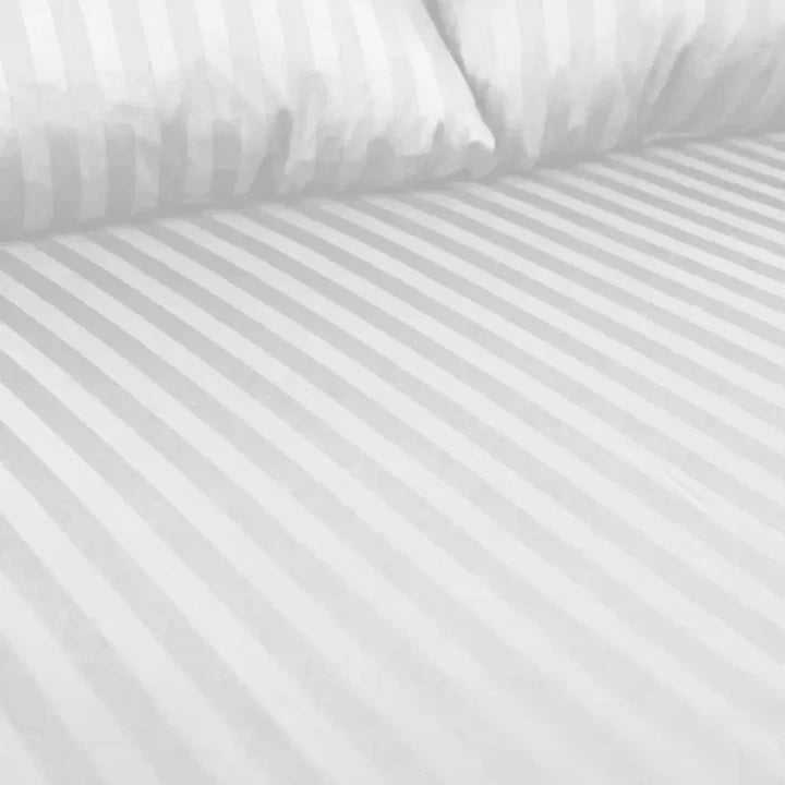Close-up of white striped bedding with a pillow.